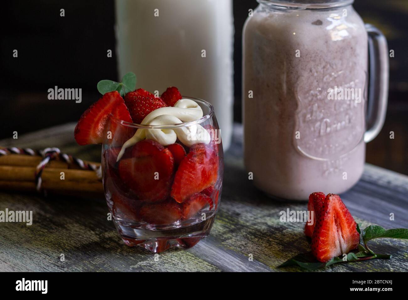 Frullato di fragole con latte su sfondo blu Foto Stock