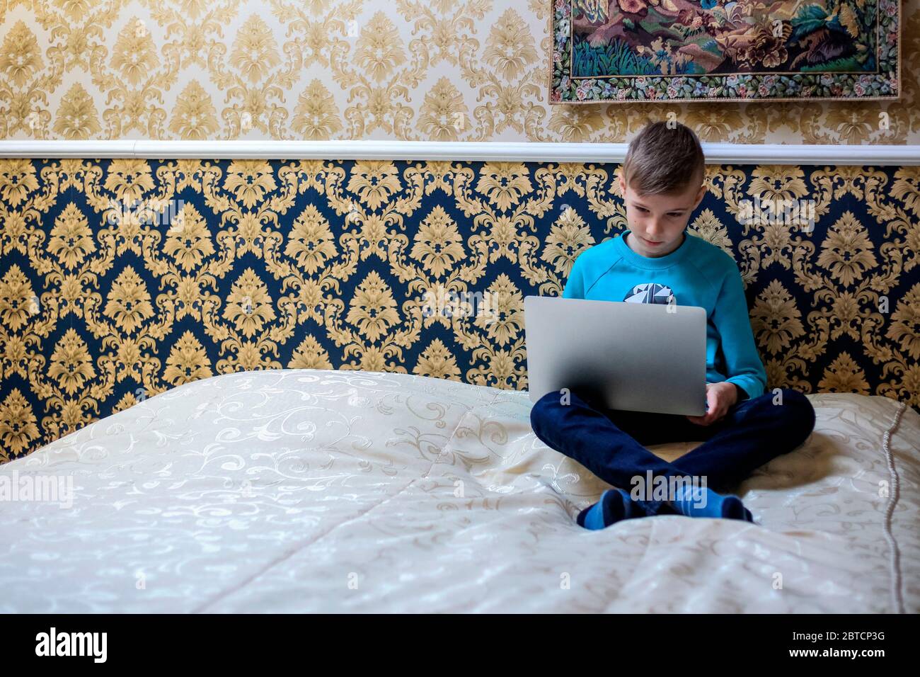 Il bambino studia da remoto in una camera d'albergo Foto Stock Il bambino studia da remoto in una camera d'albergo Foto Stock