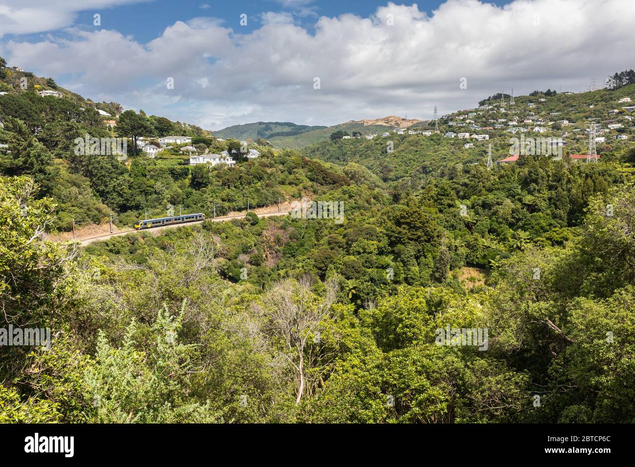 Un treno si snoda intorno ad una valle nella periferia di Wellington, Nuova Zelanda, febbraio 2020 Foto Stock