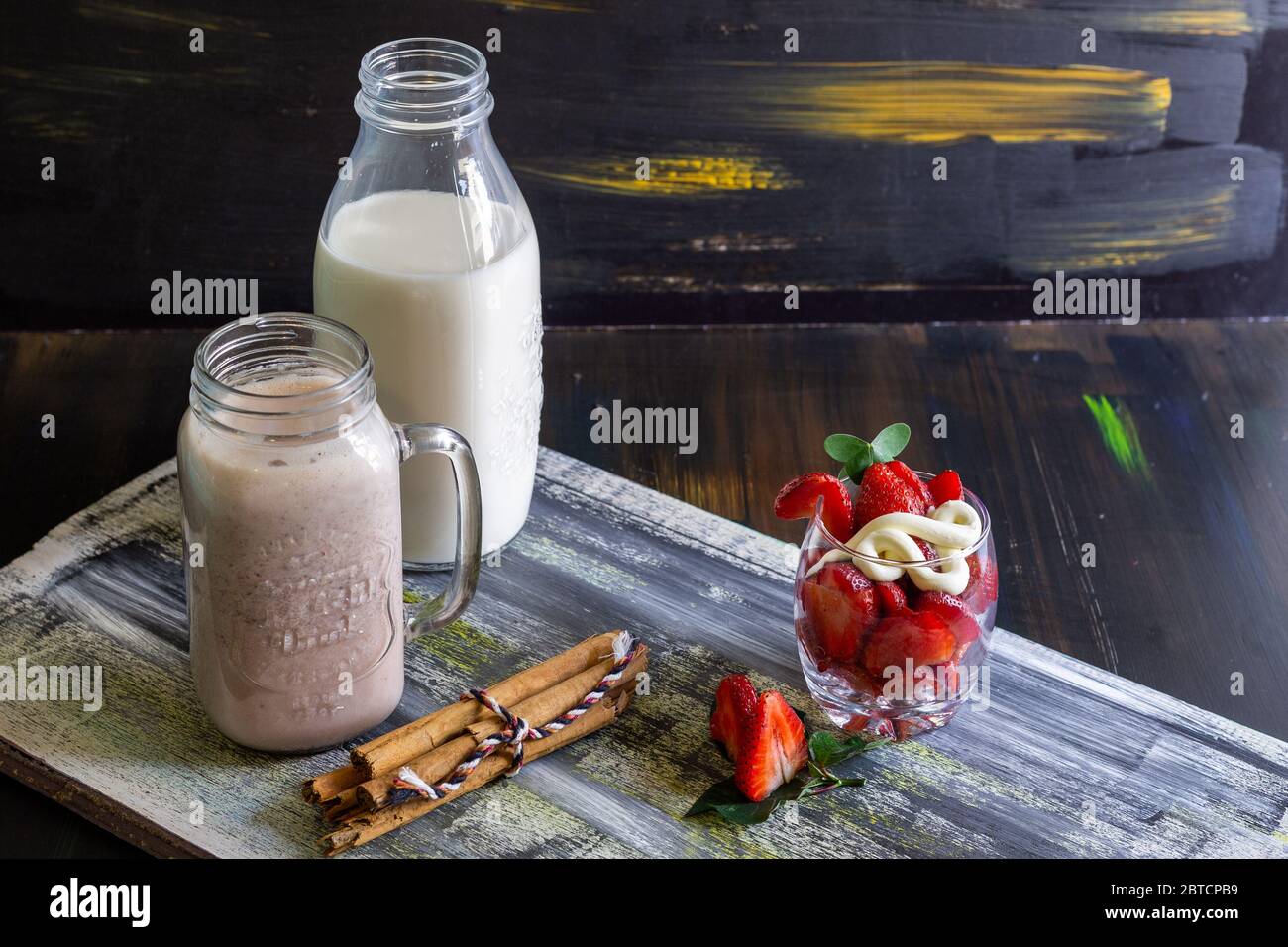 Frullato di fragole con latte su sfondo blu Foto Stock