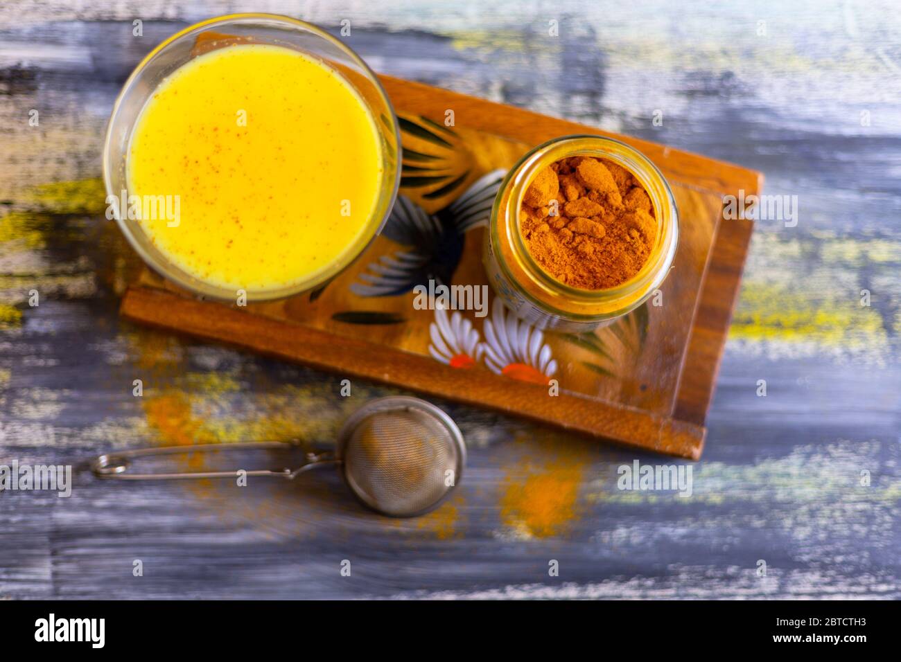 Latte in polvere dorato e un bicchiere di latte dorato. Foto Stock