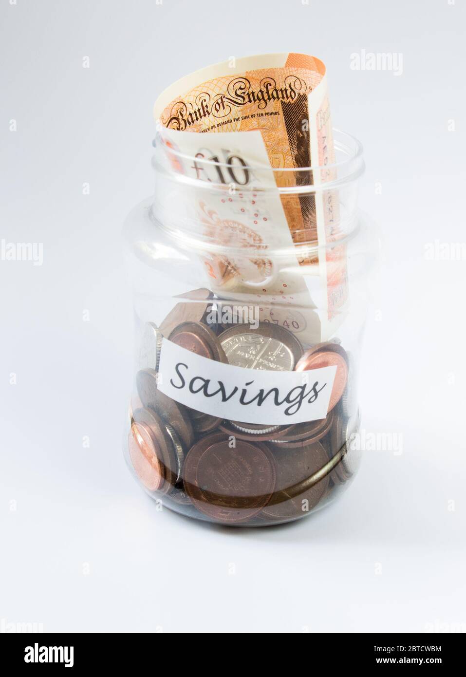 Risparmio di penny e denaro valuta di sterline britanniche in un vaso trasparente Foto Stock