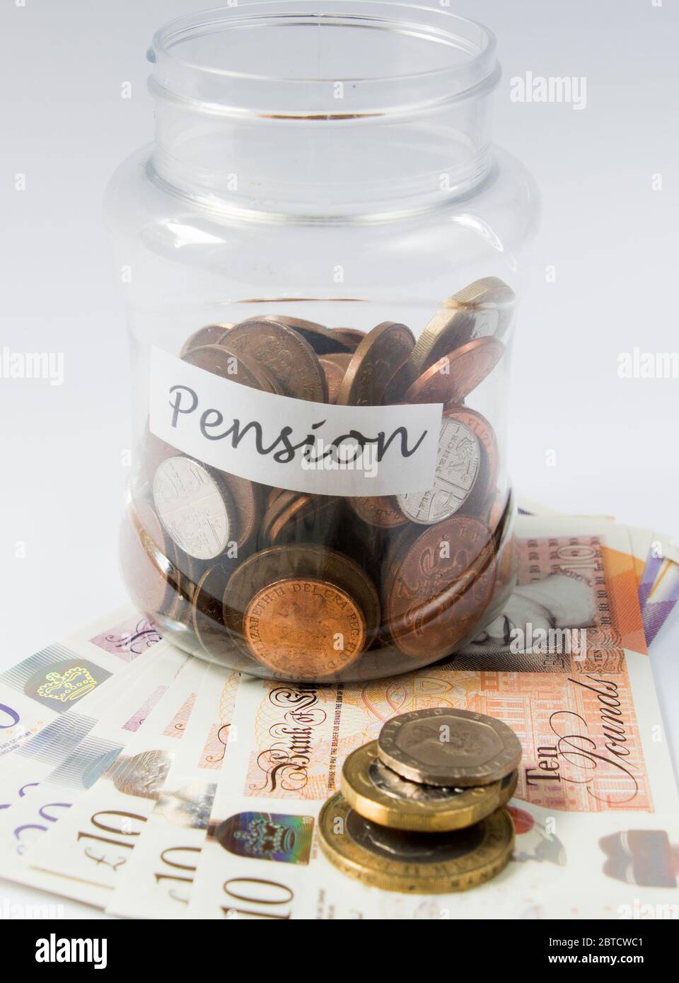 Risparmio di moneta e moneta in un vaso trasparente come banca piggy verso il piano pensionistico Foto Stock