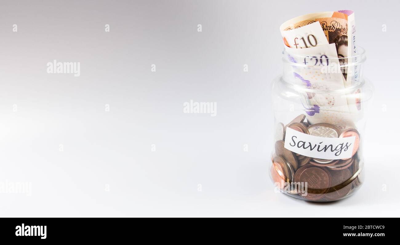 Manciata di monete e banconote in un vaso su sfondo bianco e spazio per la copia Foto Stock
