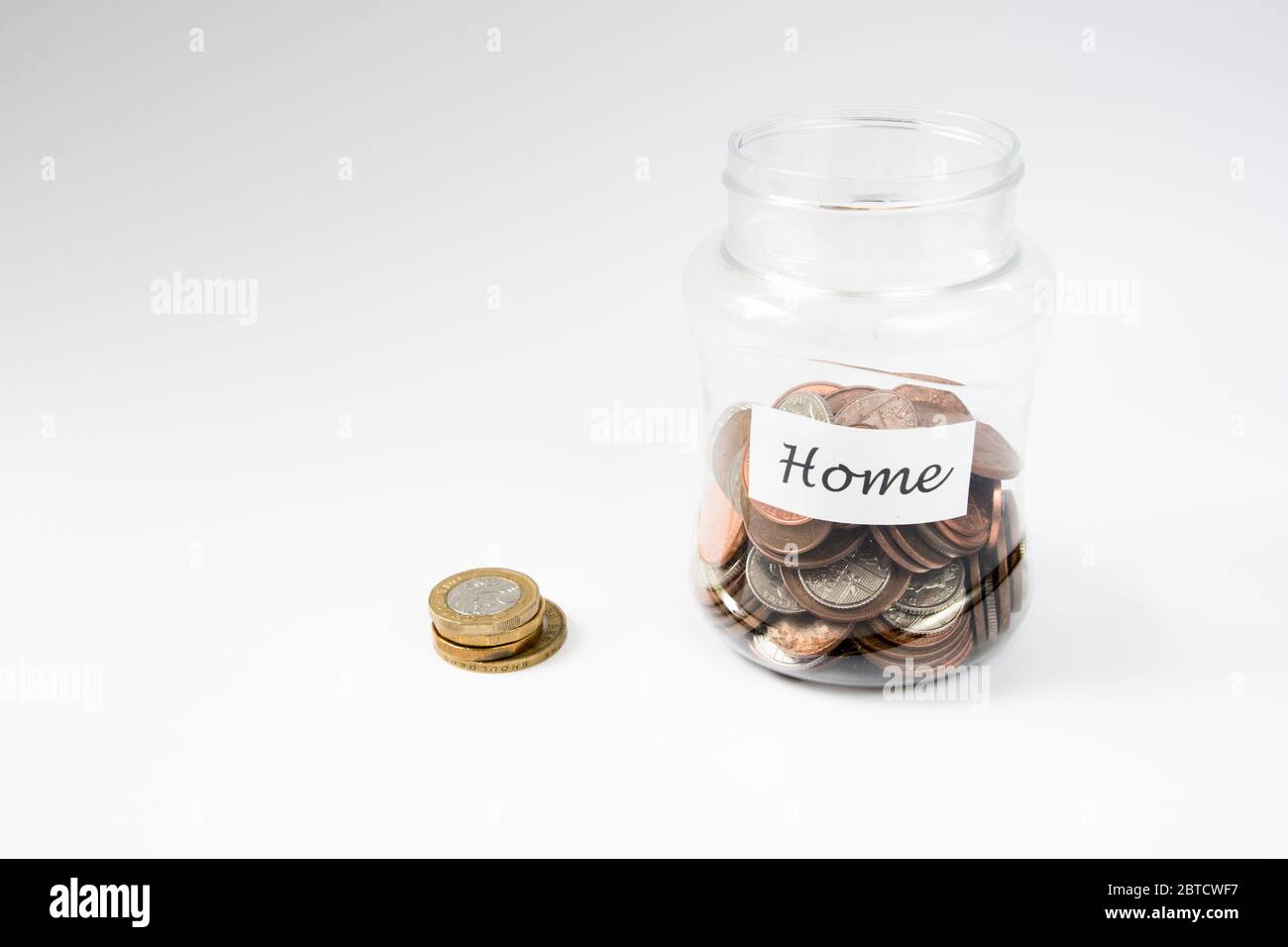 Risparmi per comprare un concetto domestico con i penny in vaso e più alto denominando le monete della libbra fuori del vaso Foto Stock