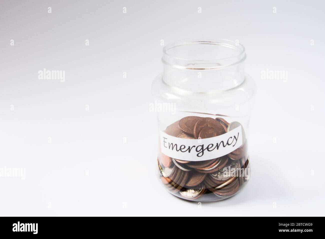 Denaro moneta risparmio in un vaso verso il fondo di emergenza Foto Stock