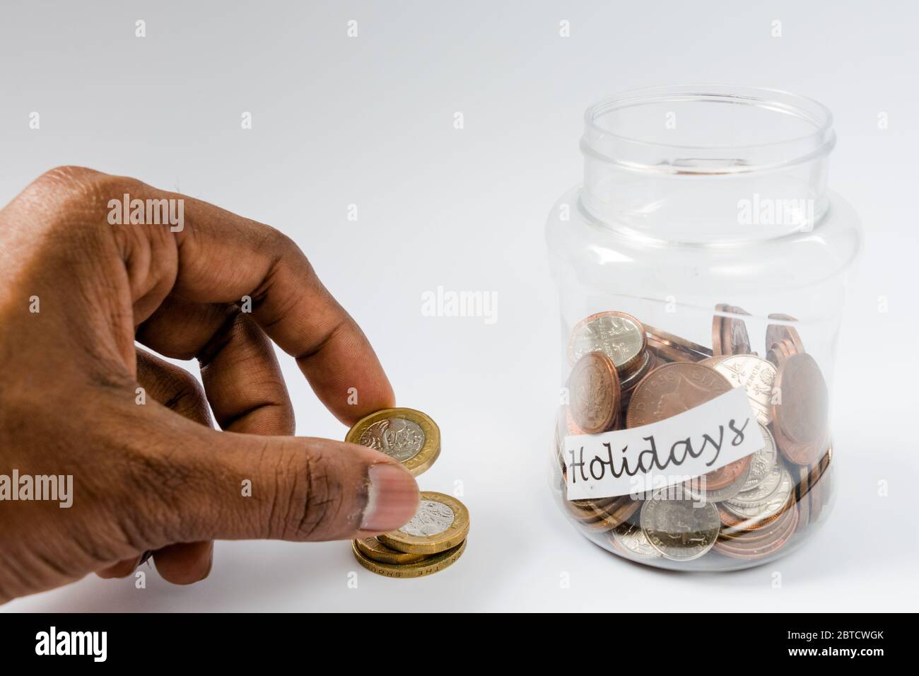 Risparmio di denaro di viaggio in un vaso trasparente riempito con penny del Regno Unito e valuta sterlina Foto Stock