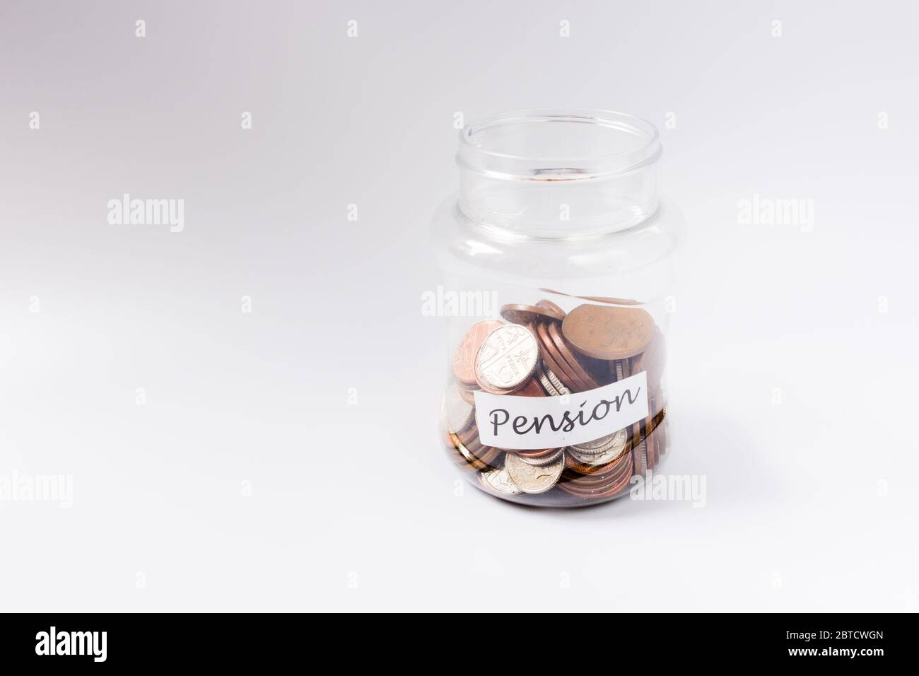 Risparmio di moneta in un vaso come banca piggy verso il fondo pensione per aiutare il pensionamento Foto Stock