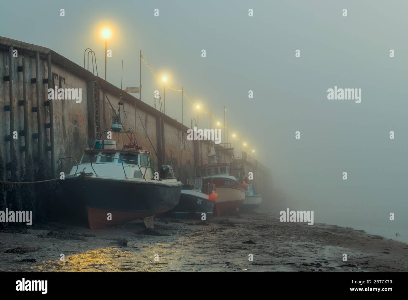 Appletore, North Devon, Inghilterra. Festa della Banca lunedì 25 maggio 2020. Regno Unito Meteo. La bassa nebbia si muove all'alba per passare le barche da pesca che costeggiano la banchina sull'estuario del fiume Torridge ad Appletore, nel Devon settentrionale. Nonostante l'inizio della giornata, il tempo dovrebbe migliorare con le previsioni del sole e della nuvola leggera per il lunedì delle festività. Credit: Terry Mathews/Alamy Live News Foto Stock