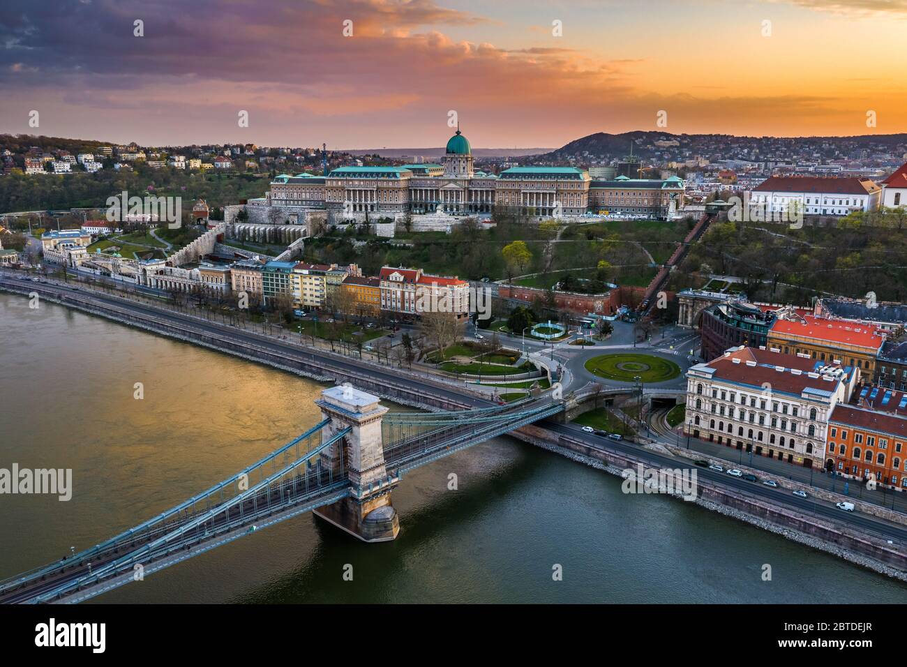 Budapest, Ungheria - veduta aerea del Ponte delle catene Szechenyi completamente vuoto con Piazza Clark Adam, il Palazzo reale del Castello di Buda e il tramonto colorato sul retro Foto Stock