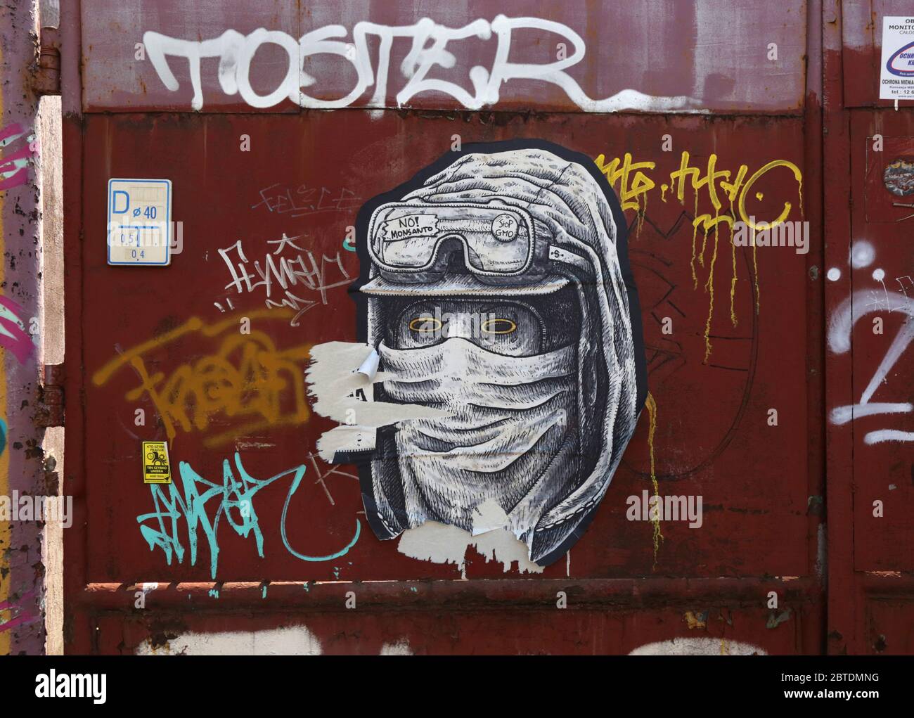Cracovia. Cracovia. Polonia. Graffiti: Viso mascherato con cappuccio e occhiali con segni 'No Monsanto' e 'Stop GMO'. Foto Stock