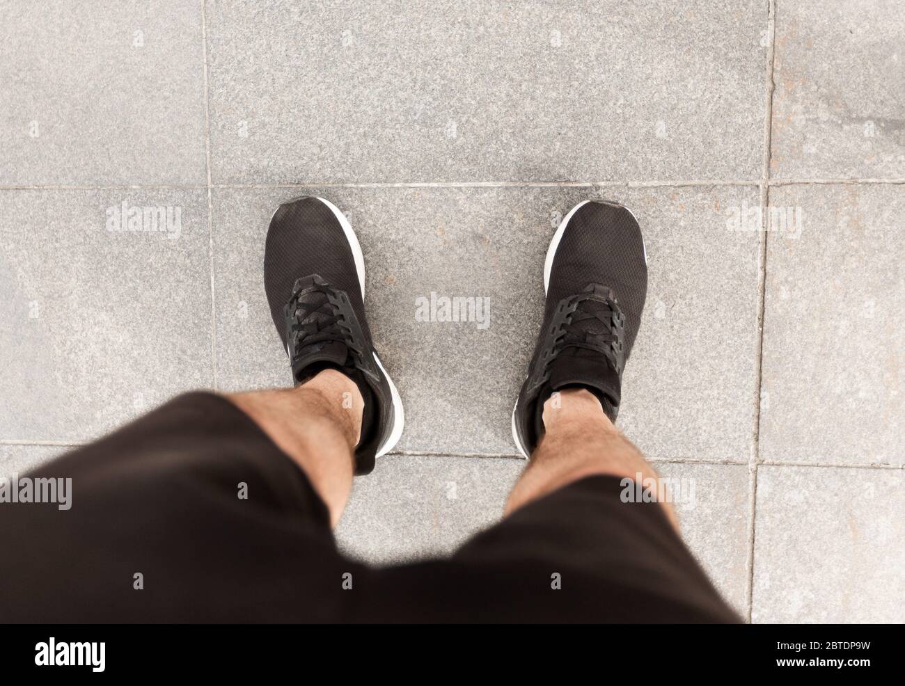 Corridore maschile guardando giù ai piedi della città Foto Stock