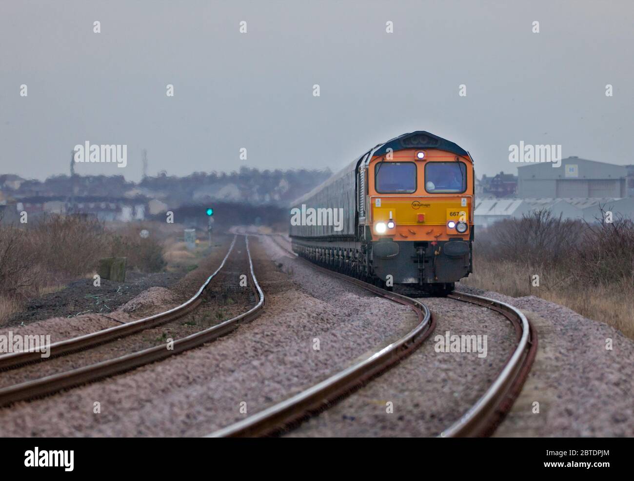 GB Railroad classe 66 locomotiva diesel 66742 passando Crimdon sulla linea ferroviaria costiera di Durham con un treno merci di carri a biomassa vuota Foto Stock