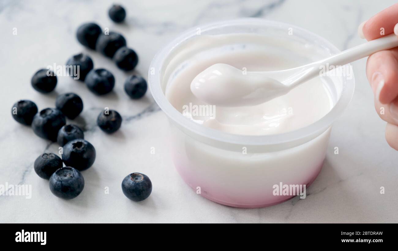 Mangiare yogurt greco. Yogurt greco puro in cucchiaio Foto Stock