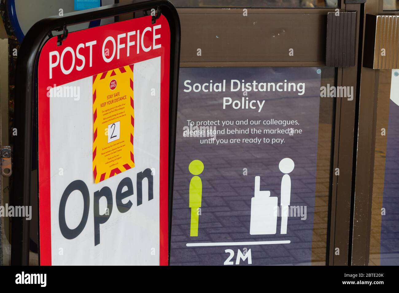 Cartelli di allontanamento sociale in una finestra locale dell'ufficio postale, Fife, Scozia Foto Stock