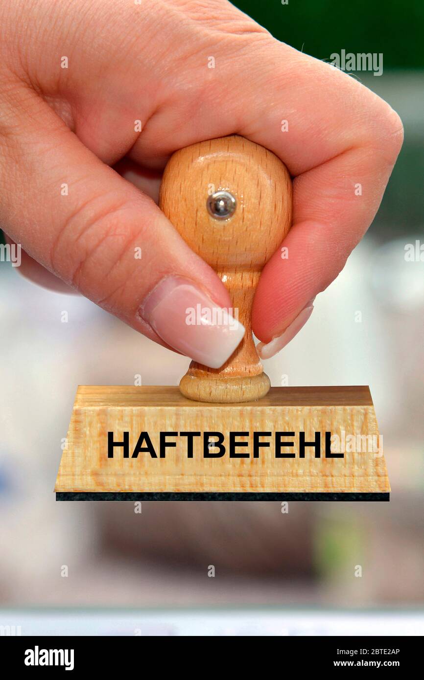 Mano con timbro in legno stampato con Haftbefehl Foto Stock