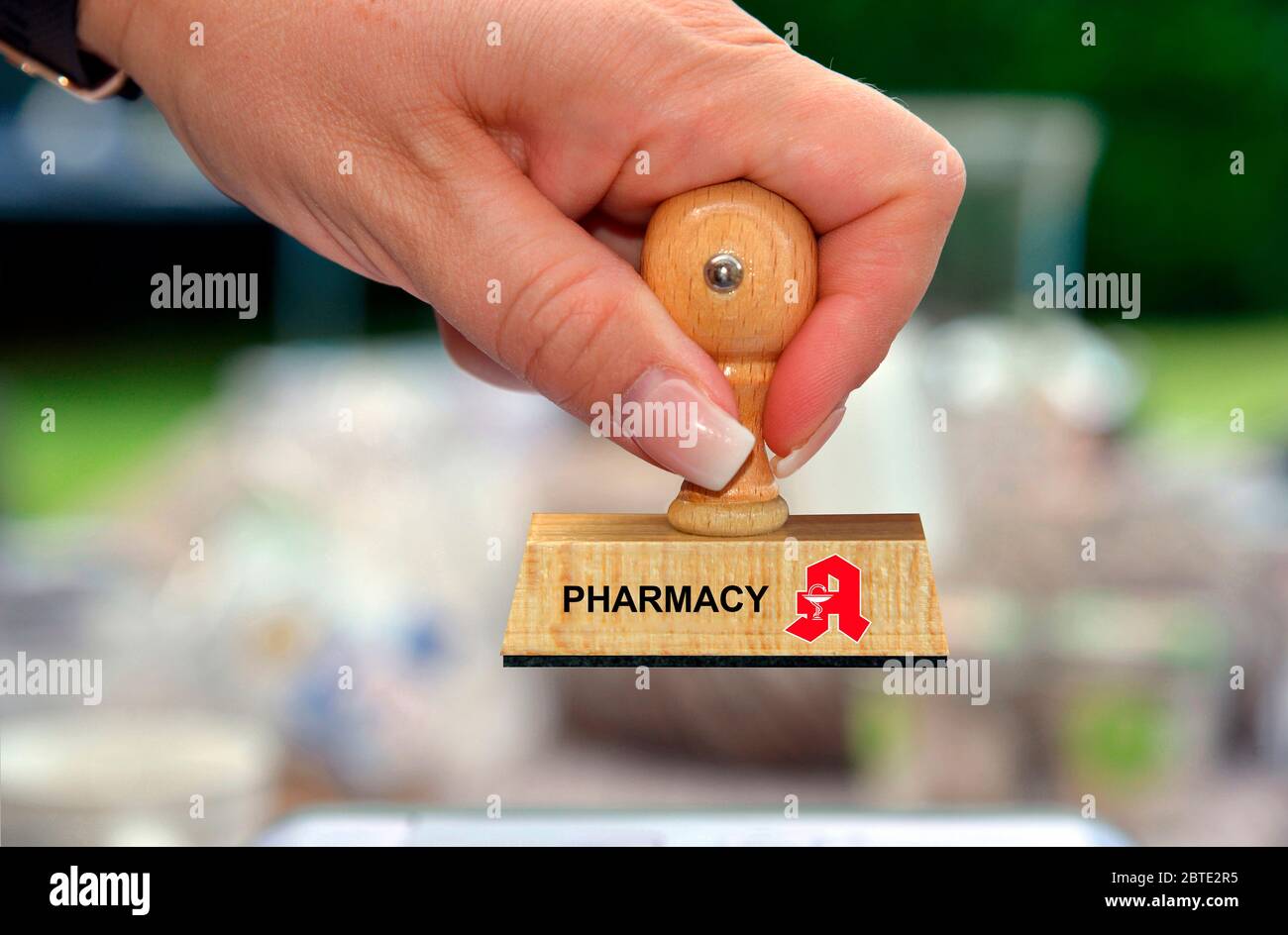 Mano con timbro in legno stampato con Farmacia e logo Foto Stock