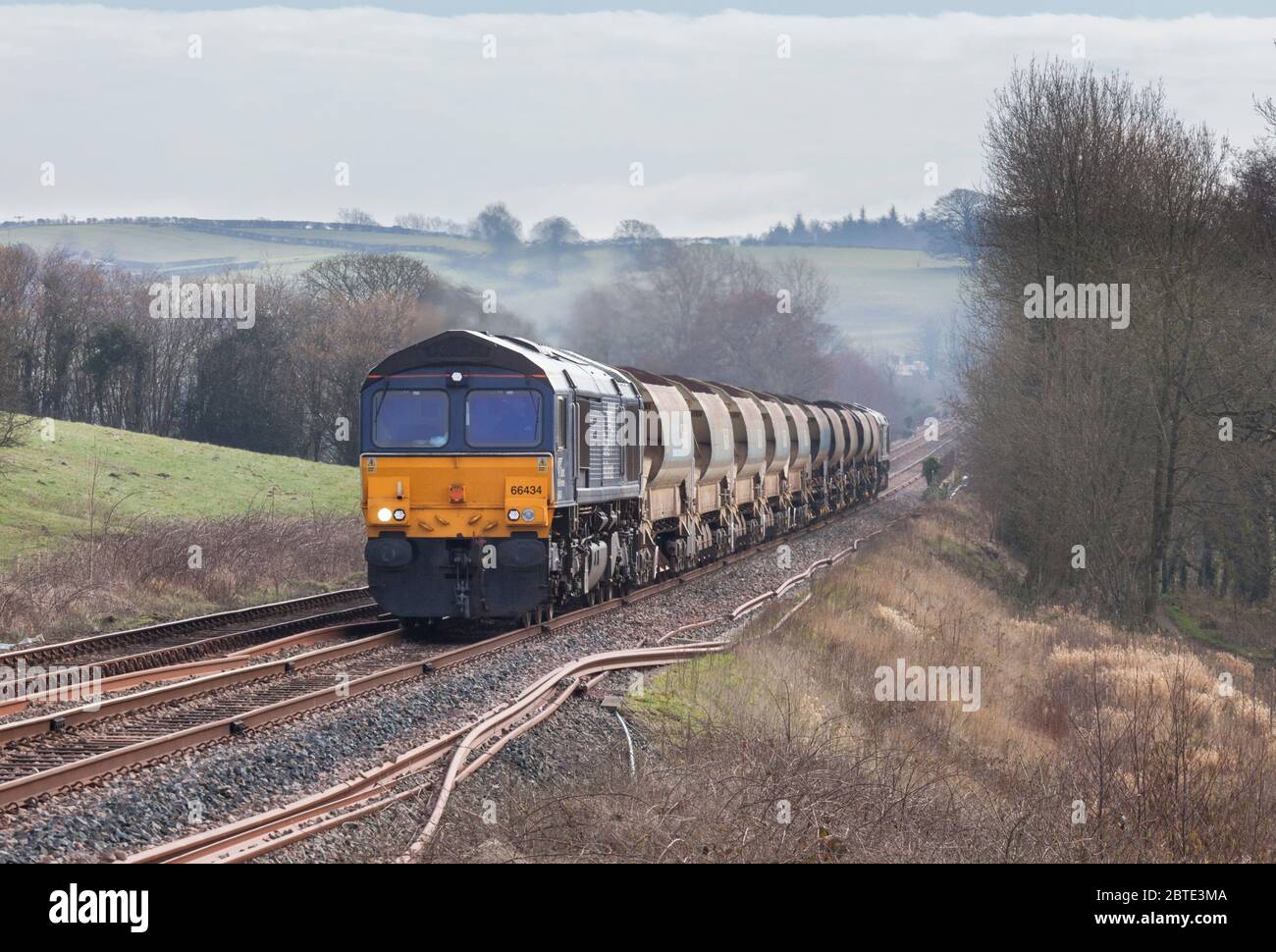 Linea diretta servizi di classe 66 locomotiva66434 trasporto di un treno di rete Ballast ad Arkholme sulla "linea ferroviaria nord-occidentale" Foto Stock