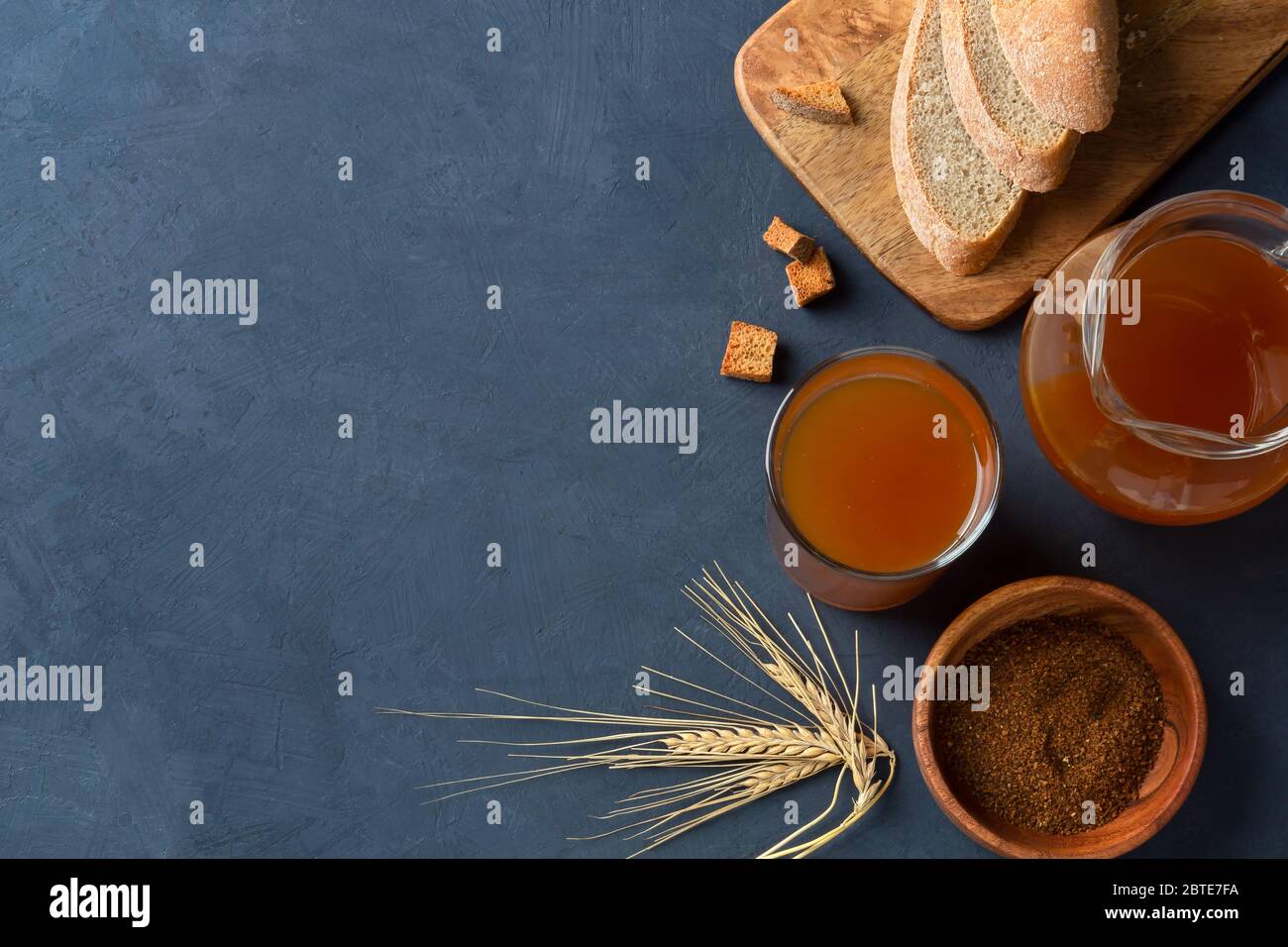 Kvass tradizionale pane drink su sfondo blu scuro, con pane di segale. Vista dall'alto, spazio di copia. Foto Stock