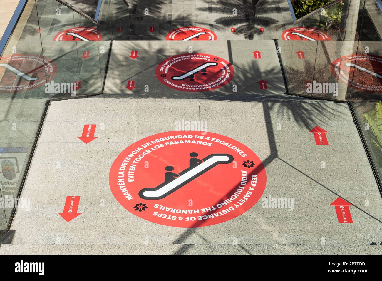 Centro commerciale Siam, Costa Adeje, Tenerife, Isole Canarie, Spagna. 25 maggio 2020. Fase due de-escalation del Covid19, Coronavirus Stato di emergenza consente centri commerciali di aprire con la regolamentazione dei numeri, maschere facciali obbligatorie per il personale e i clienti e mantenendo una distanza di due metri. Le frecce di direzione sulle scale e le indicazioni sul pavimento consigliano ai clienti di mantenere una distanza di due metri. Foto Stock