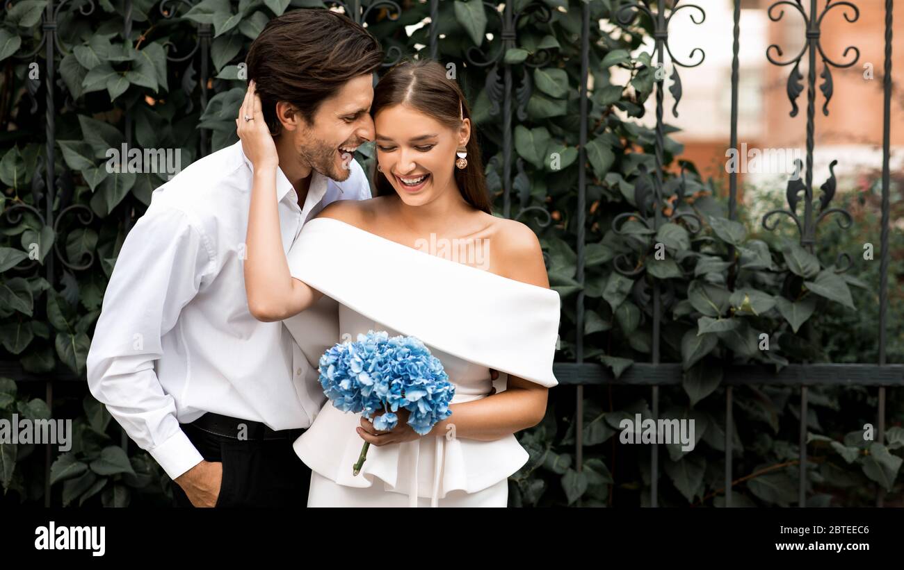 Coppia il giorno del matrimonio abbracciare divertirsi all'aperto in città Foto Stock