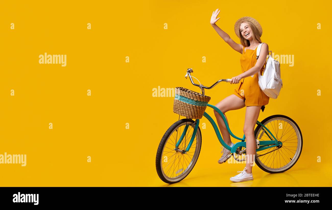 Ciao, estate. Bicicletta d'epoca positiva per giovani Girl Riding e mano ondulata Foto Stock