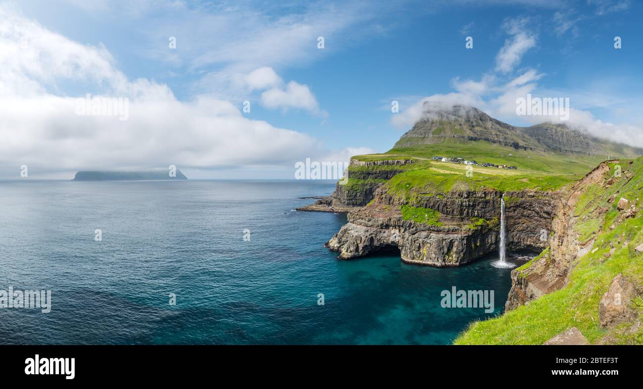 Incredibile vista giorno della cascata Mulafossur nel villaggio di Gasadalur, Vagar Island delle Isole Faroe, Danimarca. Fotografia di paesaggio Foto Stock