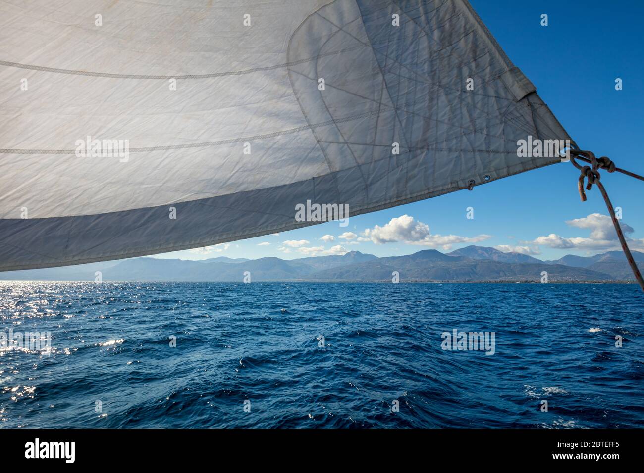 Barca a vela con vela in mare aperto vicino alle isole, Grecia Foto Stock