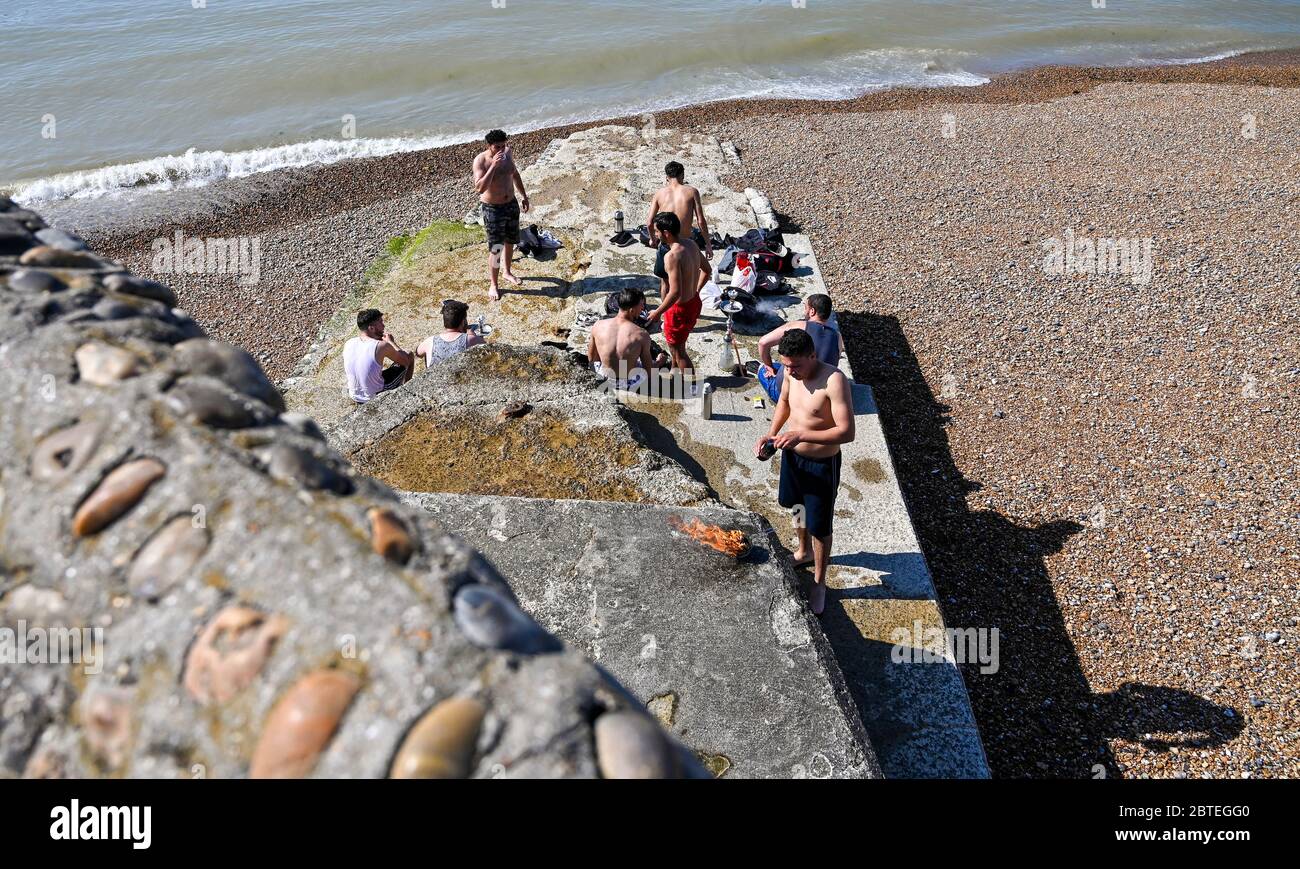 Brighton UK 25 maggio 2020 - i giovani uomini ottengono la festa andando presto sulla spiaggia di Brighton oggi in una giornata calda di sole. Si prevede che le folle si affollino in luoghi di bellezza e spiagge intorno al paese durante le vacanze in banca, poiché si prevede che le temperature raggiungano gli alti 20 anni nel sud-est dell'Inghilterra durante la crisi pandemica di Coronavirus COVID-19 . Credit: Simon Dack / Alamy Live News Foto Stock