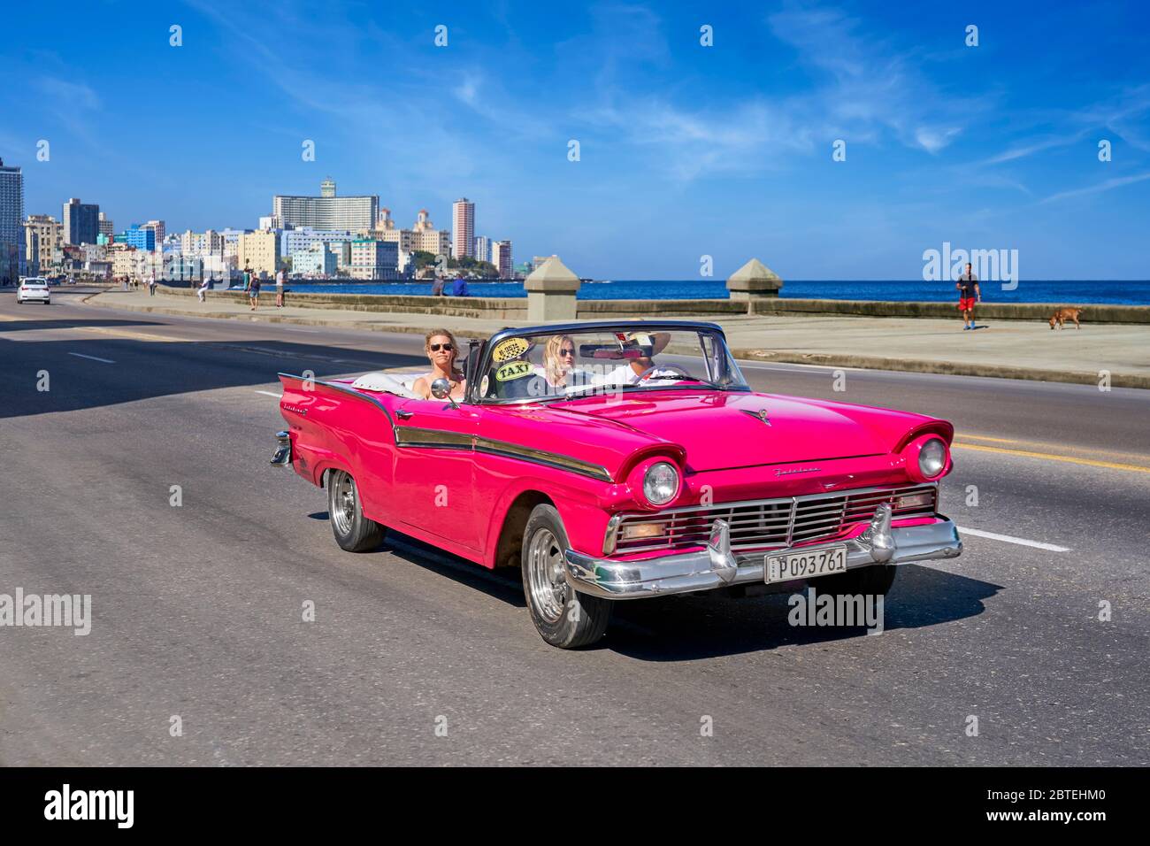 Auto vecchia rossa che percorre Malecon, l'Avana, Cuba Foto Stock