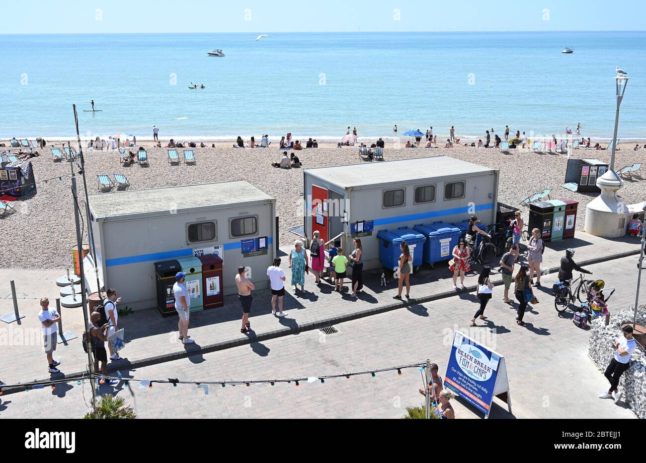 Brighton UK 25 maggio 2020 - i visitatori coda per i servizi igienici pubblici come si gode la festa della banca caldo sole sulla spiaggia di Brighton oggi come si prevede che le temperature raggiungere gli alti 20 's nel sud-est dell'Inghilterra durante la crisi pandemica Coronavirus COVID-19 . Credit: Simon Dack / Alamy Live News Foto Stock