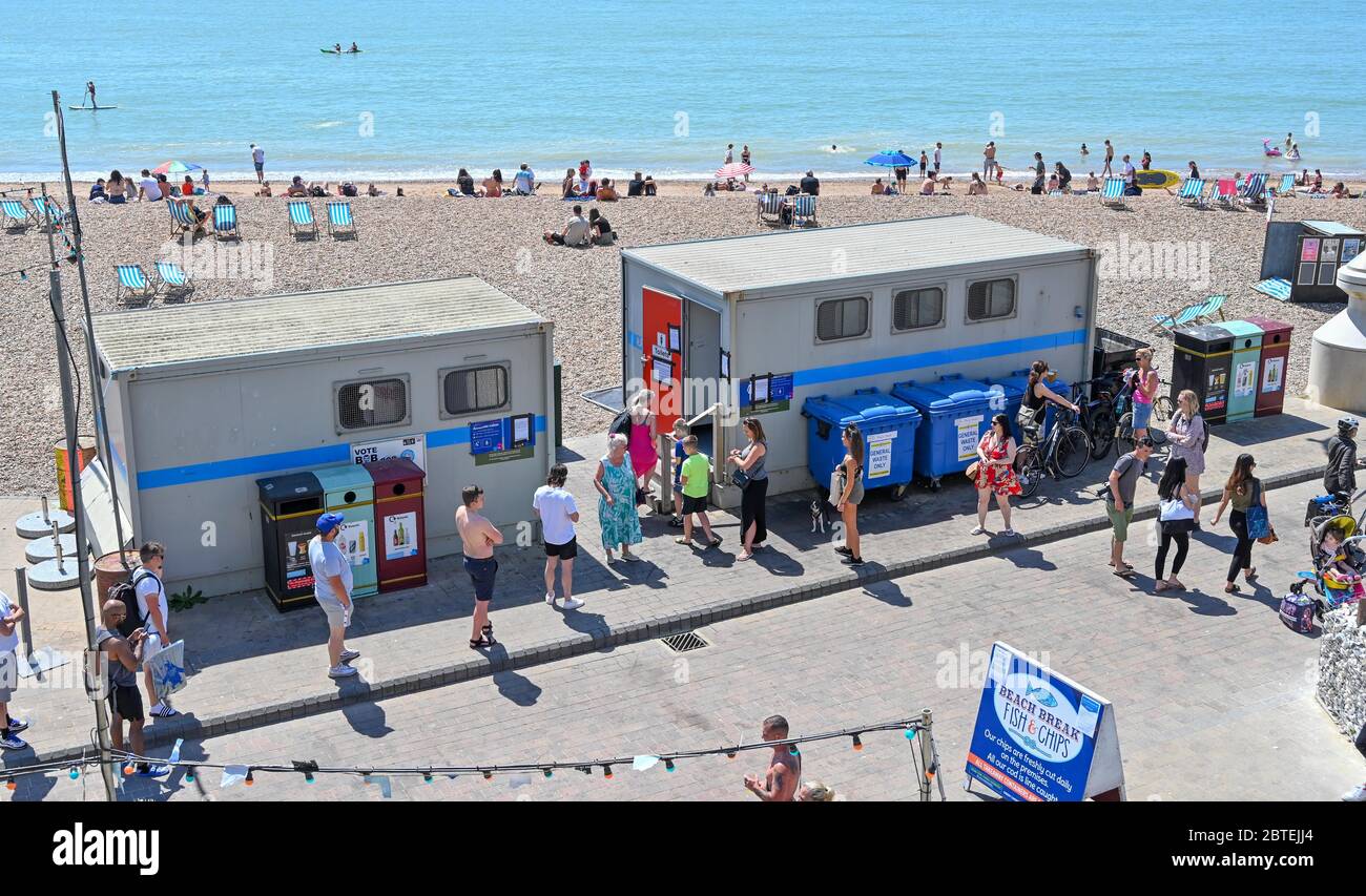 Brighton UK 25 maggio 2020 - i visitatori coda per i servizi igienici pubblici come si gode la festa della banca caldo sole sulla spiaggia di Brighton oggi come si prevede che le temperature raggiungere gli alti 20 's nel sud-est dell'Inghilterra durante la crisi pandemica Coronavirus COVID-19 . Credit: Simon Dack / Alamy Live News Foto Stock