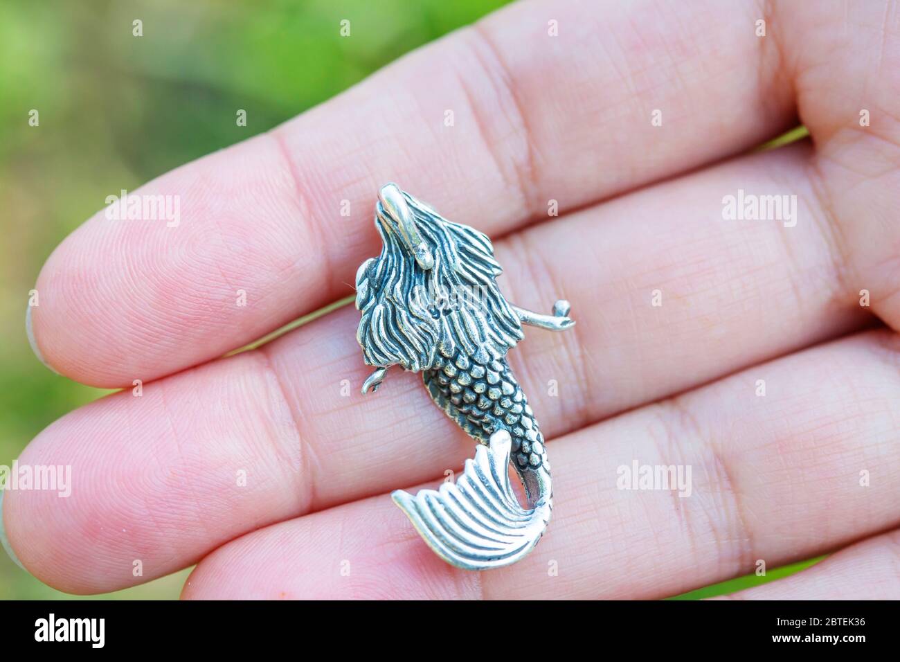 Pendente in argento sterling a forma di sirena sulla mano femminile Foto Stock