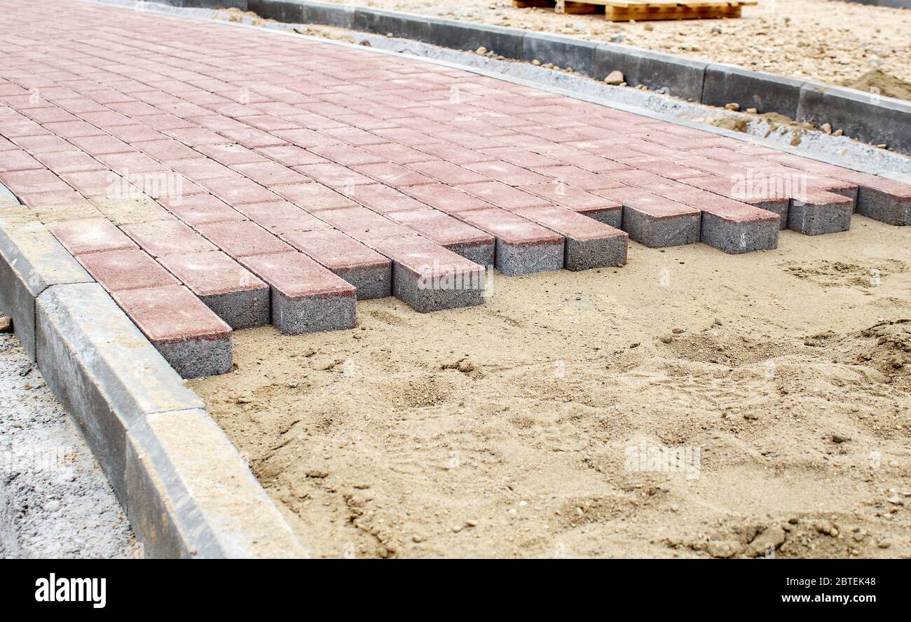 costruzione di un nuovo marciapiede moderno fatto di piastrelle all'aperto  in giornata di sole Foto stock - Alamy