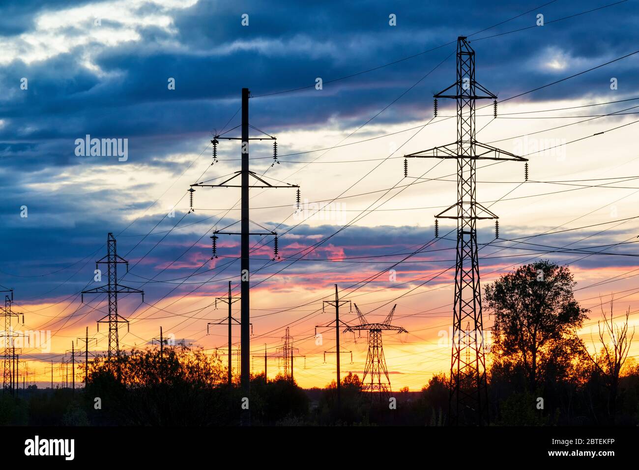 Linee elettriche contro il cielo tramontato. Paesaggio industriale Foto Stock