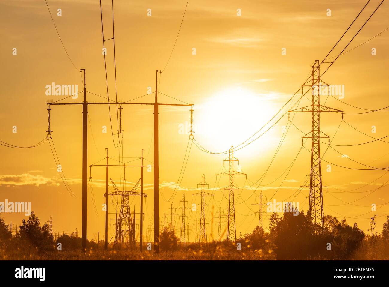 Linee di alimentazione ad alta tensione al tramonto. Paesaggio industriale Foto Stock