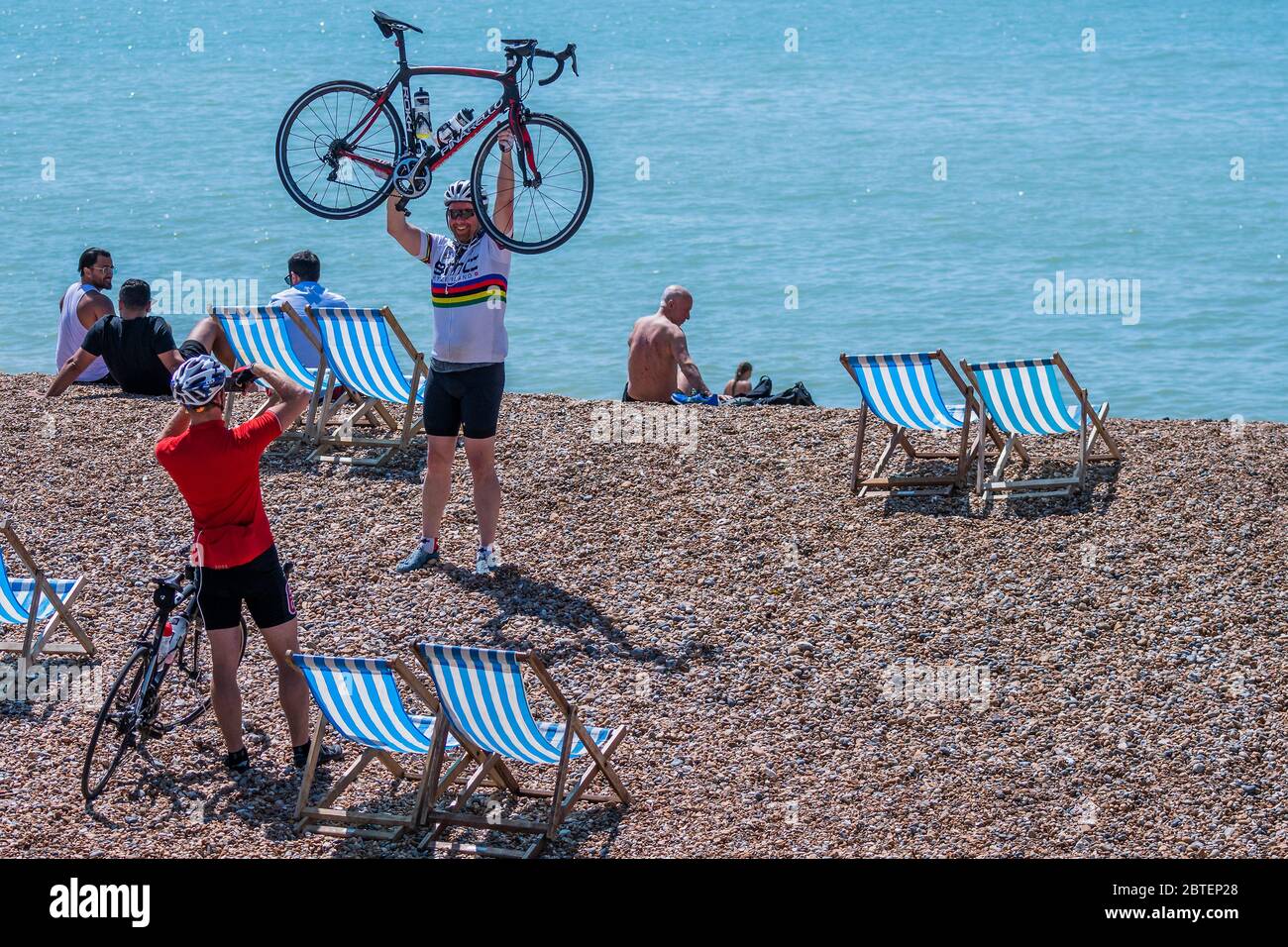 Brighton, Regno Unito. 25 Maggio 2020. Un ciclista celebra il suo successo in bicicletta a Brighton - è soleggiato e la gente viene alla spiaggia e al mare a Brighton, durante le vacanze della Banca Lunedi. È occupato ma ancora plentyu di spazio per la distanza sociale. Il "blocco" dei morti continua per l'epidemia di Coronavirus (Covid 19). Credit: Guy Bell/Alamy Live News Foto Stock