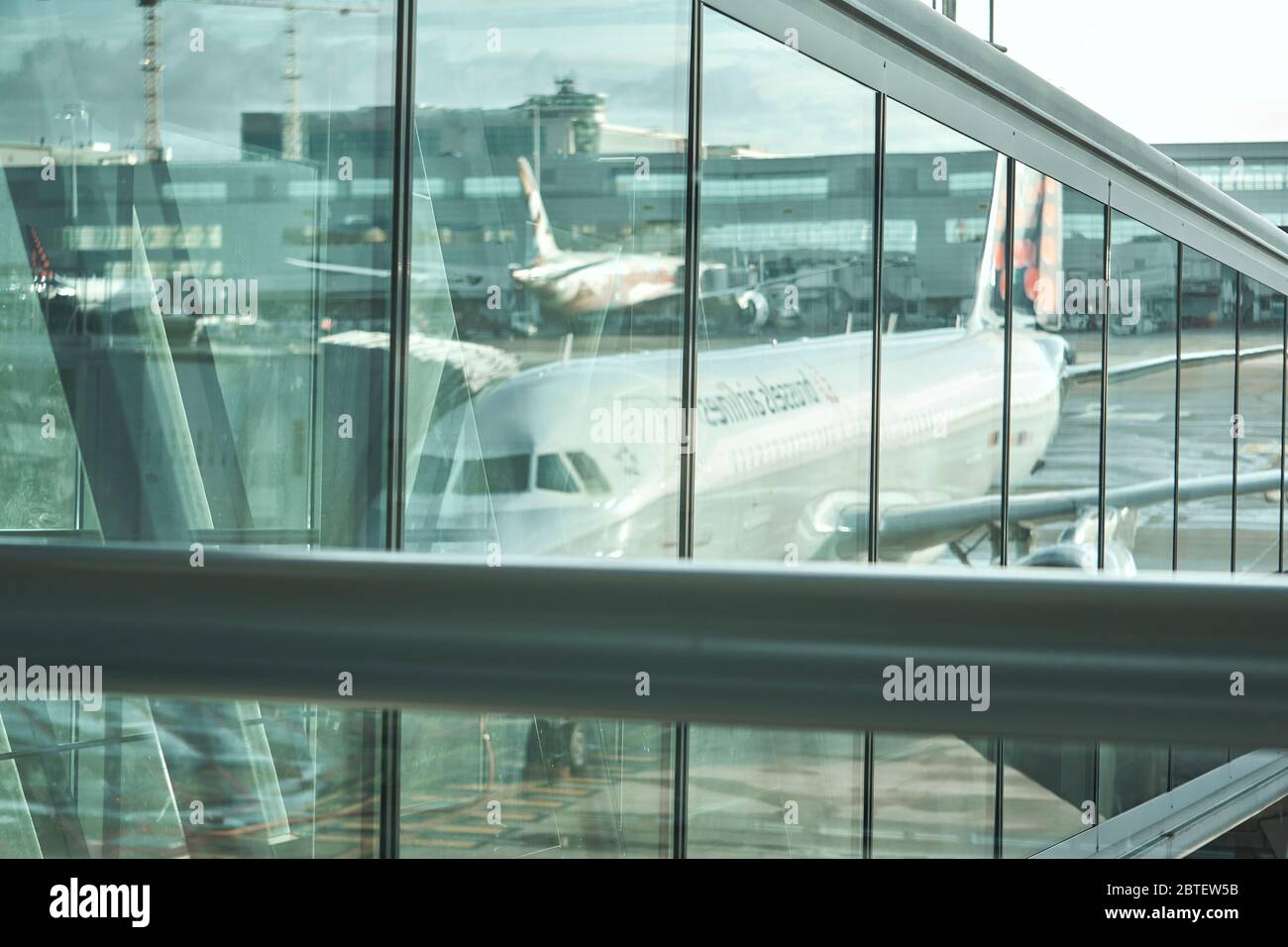 Gli aerei Airbus si riflettevano nella parete di vetro dell'aeroporto di Bruxelles, insieme agli edifici e ad altri oggetti di artigianato sullo sfondo Foto Stock