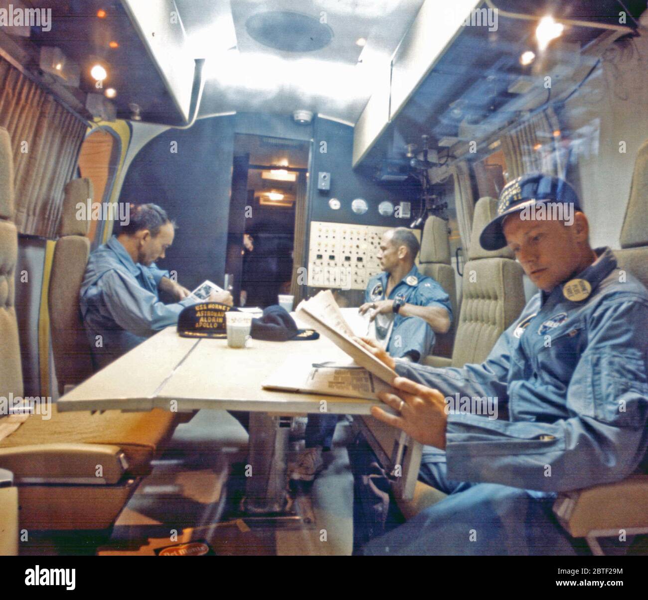 Entro il Mobile impianto di quarantena, Apollo 11 astronauti (da sinistra a destra) Michael Collins, Edwin E. Aldrin Jr e Neil Armstrong A. rilassatevi seguendo il loro successo atterraggio lunare di missione. Hanno trascorso due-e-un-metà giorni nella quarantena rimorchio lungo il tragitto da La USS Hornet, primo recupero nave lunare Laboratorio di ricezione al veicolo spaziale con equipaggio Center a Houston. Foto Stock