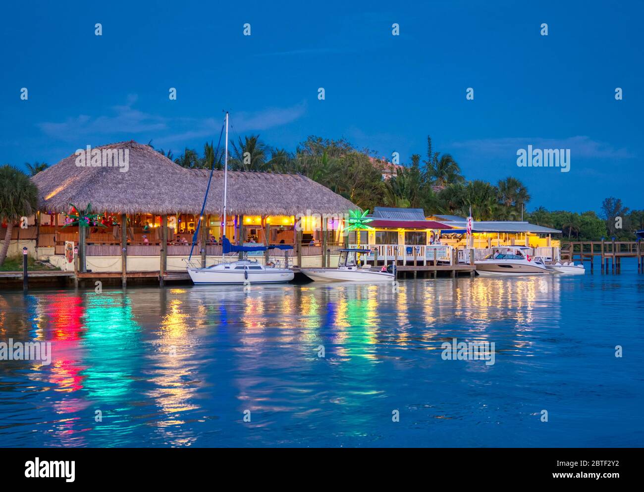 Pope Sunset Grill al crepuscolo con luci che si riflettono nel canale Intracoastal del Golfo di Nokomis, Florida Foto Stock