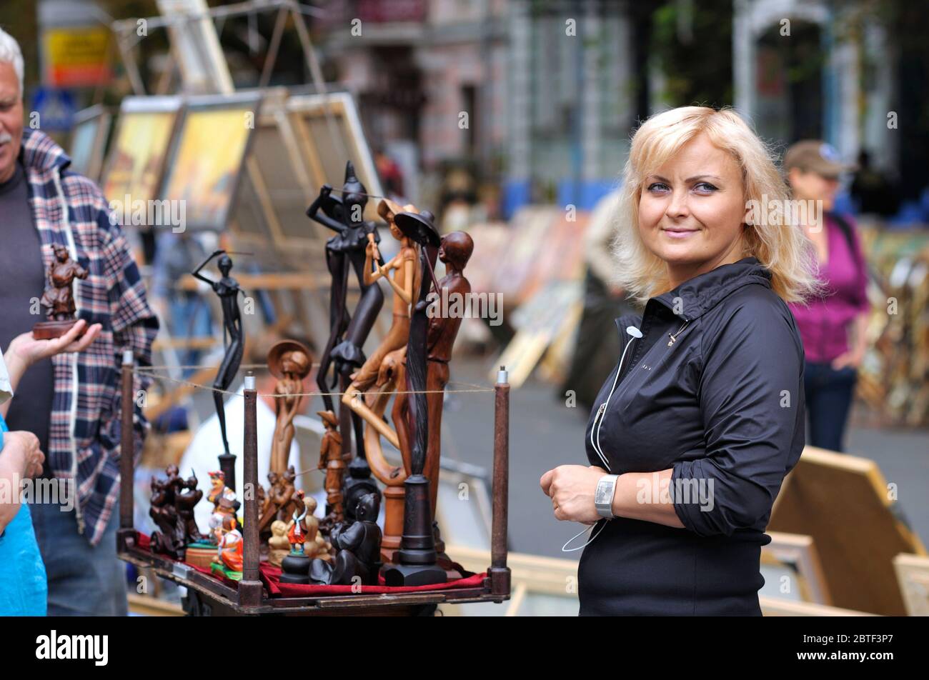 Mini sculture in legno messe in vendita durante la fiera di strada, artista donna in piedi vicino a venderle. 24 agosto 2013. Kiev, Ucraina, il Andreevsky des Foto Stock