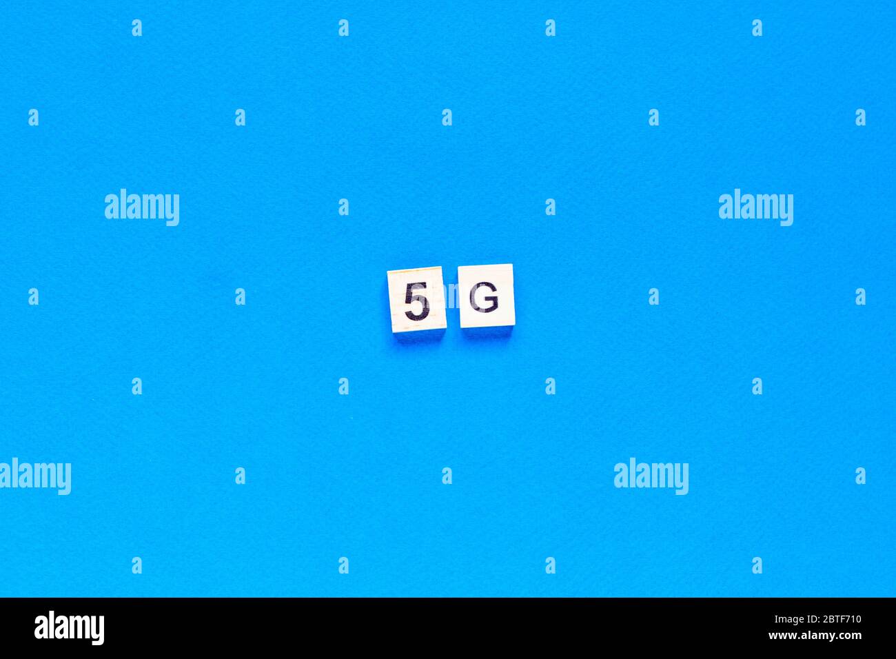 5 G. cinque G, scritte in lettere di legno su sfondo blu. Layout piatto. Rete wireless. Nuova tecnologia. Vista dall'alto. Foto Stock