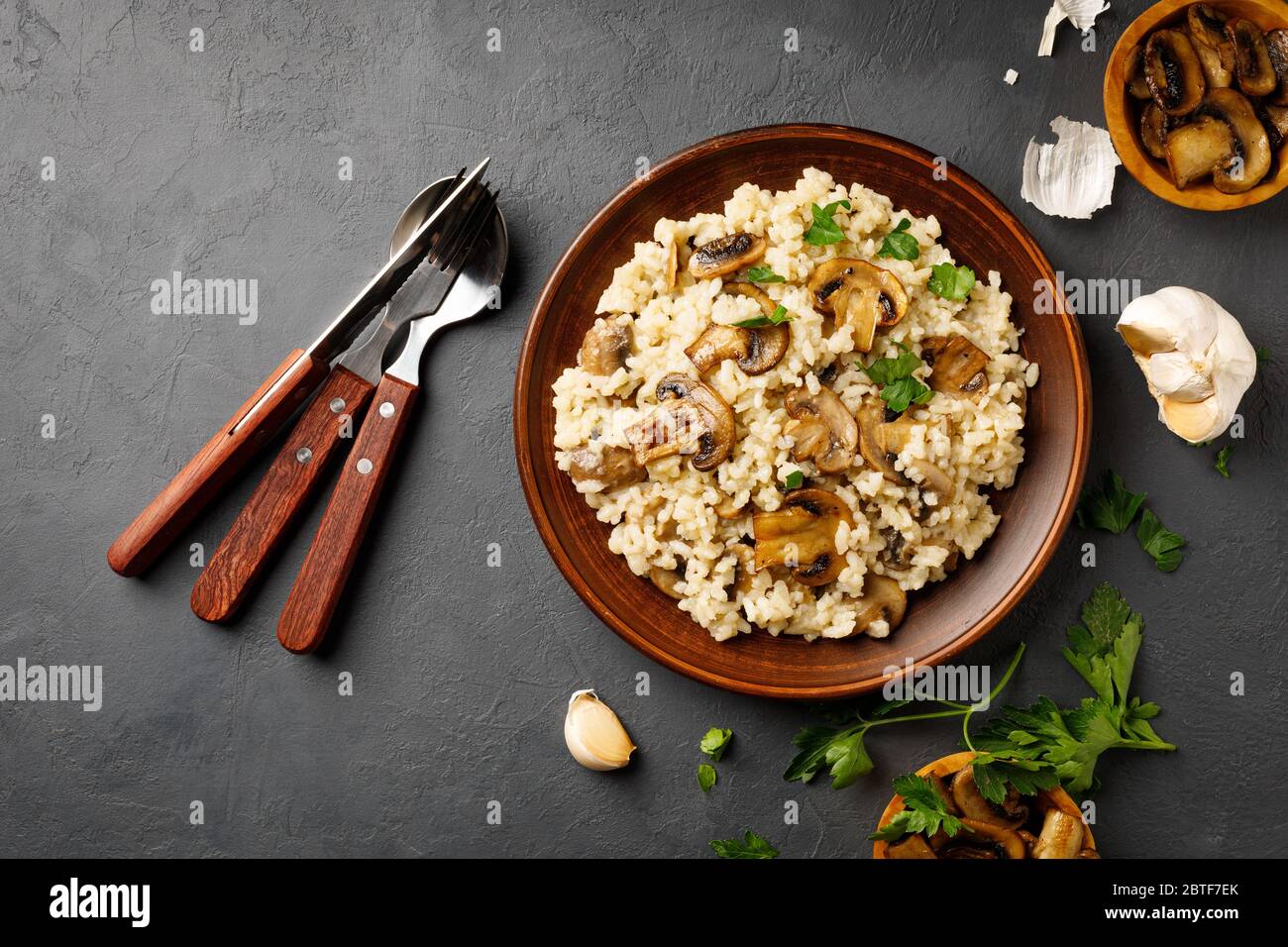 Pasto tradizionale di cucina italiana - risotto vegetariano con funghi. Pietra nera. Foto Stock