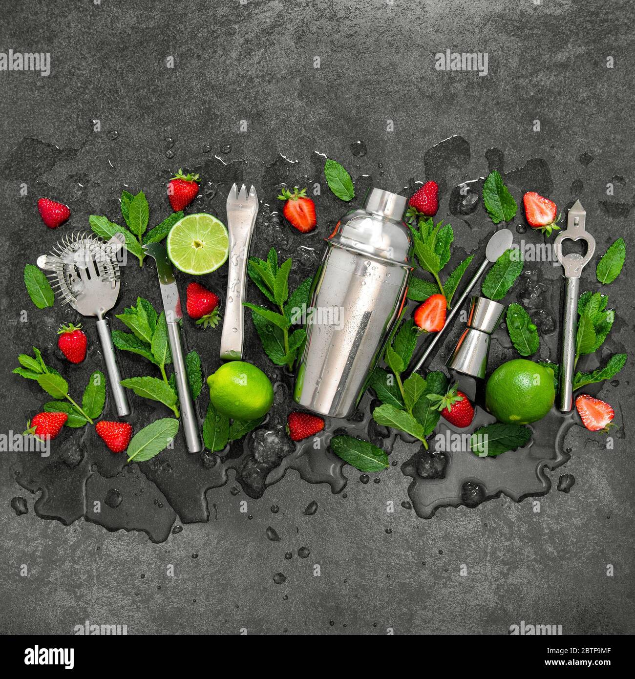 Strumenti da bar e ingredienti per cocktail di fragole, lime, menta, ghiaccio Foto Stock
