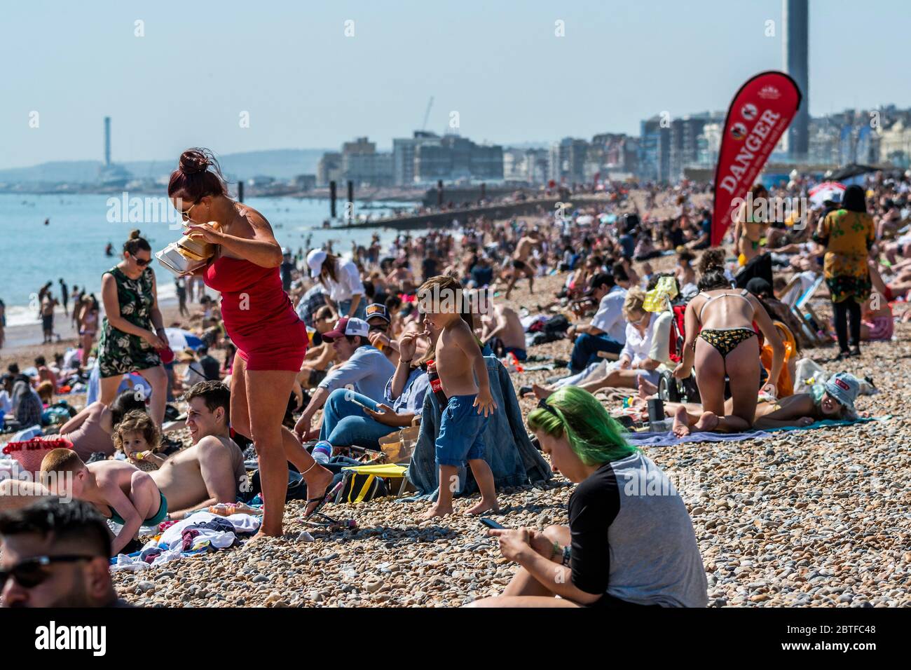 Brighton, Regno Unito. 25 Maggio 2020. E' soleggiata e la gente viene in spiaggia e sul mare a Brighton, durante le vacanze di Lunedi'. È occupato ma ancora plentyu di spazio per la distanza sociale. Il "blocco" dei morti continua per l'epidemia di Coronavirus (Covid 19). Credit: Guy Bell/Alamy Live News Foto Stock