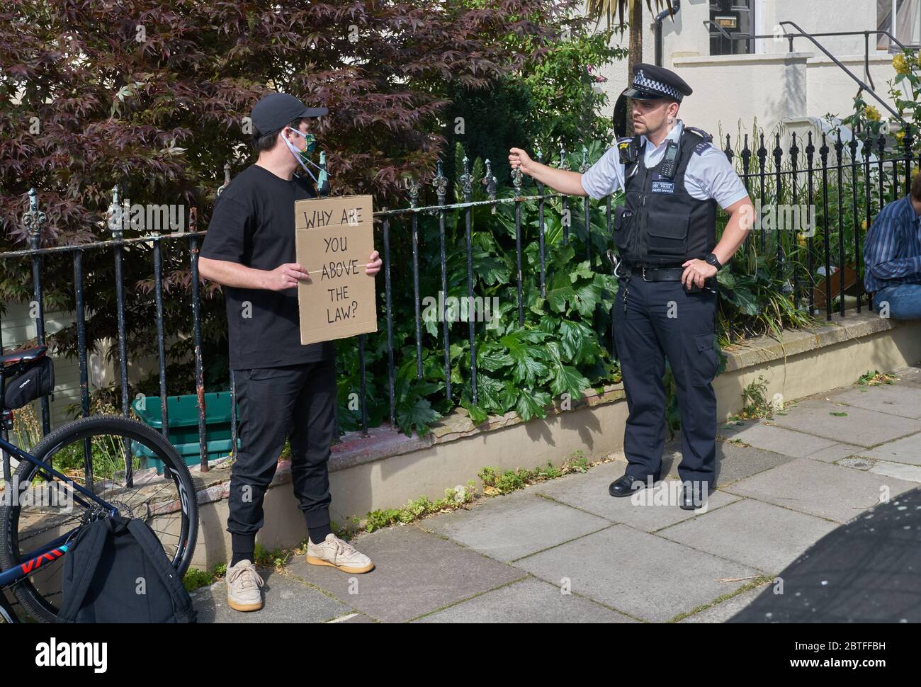 poliziotto parla con il protestore presso la vicina casa di dominic cummings Foto Stock