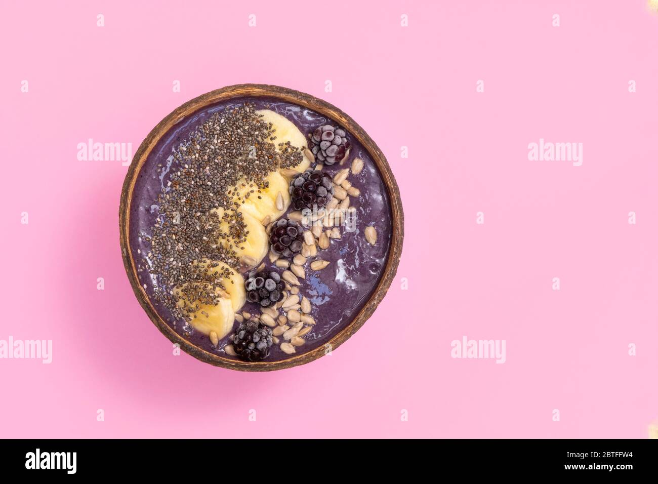 Superfood blackberry avocado frullato ciotola su sfondo rosa pastello. Immagine con spazio di copia, vista dall'alto Foto Stock