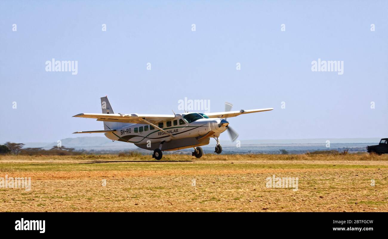Volo aereo regionale decollo, pista di terra, movimento, eliche girando velocemente, ruote fuori terra, piccoli aerei, viaggio, trasporto, Tanzania; Africa Foto Stock