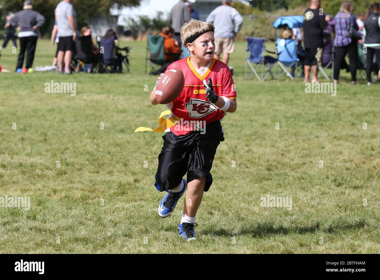 Bandiera giovanile gioco di calcio tiro di quarterback alla ricerca di un ricevitore aperto. Foto Stock
