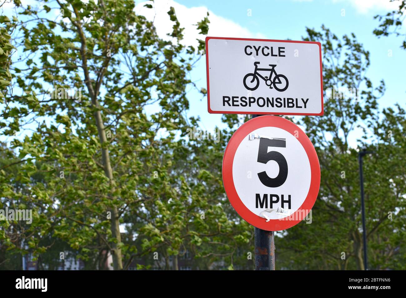 Il cartello britannico indica responsabilmente il limite di velocità di 8 km all'ora in un parco. I cittadini si sposteranno in bicicletta o potranno godersi un piacevole giro in città Foto Stock